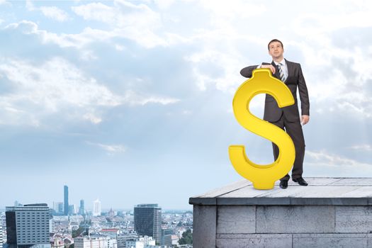 Businessman standing with big dollar sign on building roof