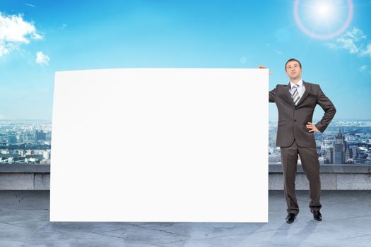 Businessman standing with big paper with blank screen