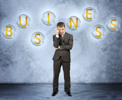 Thinking businessman with word business on grey background