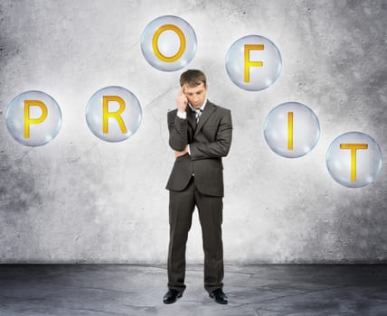Thinking businessman with word profit on grey background