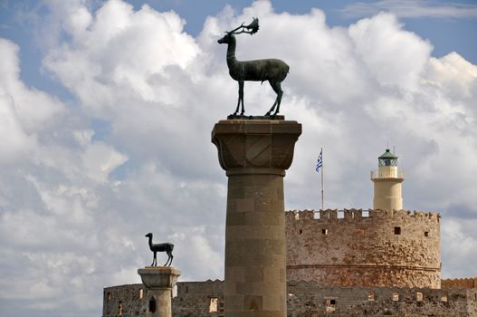 St. Nicholas fortress, now a lighthouse, guards the mouth of Mandraki Harbour on Rhodes. Twin statues of Rhodian deer stand on top of columns either side of the harbour entrance, once the site of the legendary Colossus of Rhodes.