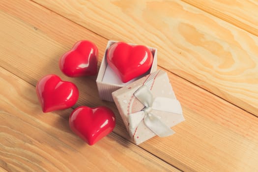 Gift of love. hearty gift. A gift box with a red heart inside. On the wooden floor