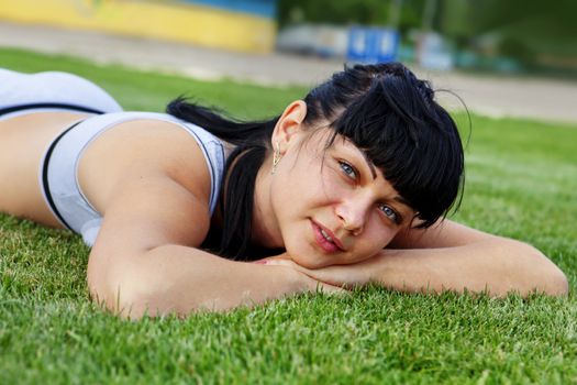 closeup of beautiful dreamy woman face that lies on grass