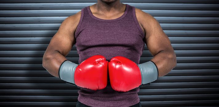 Fit man with boxing gloves  against grey shutters