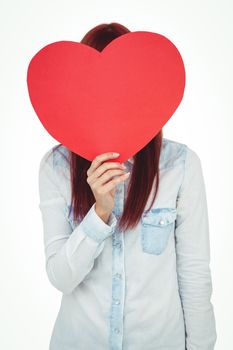 Attractive hipster woman behind a red heart against white background