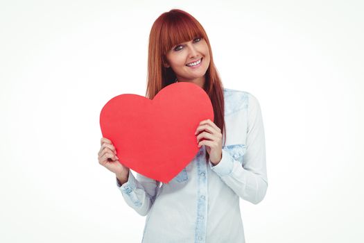 Attractive hipster woman behind a red heart against white background