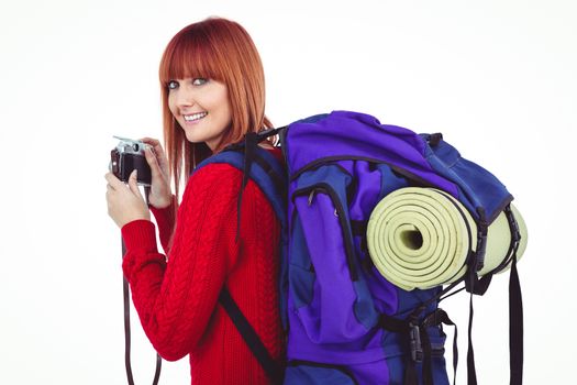 Smiling hipster woman with a travel bag against white background