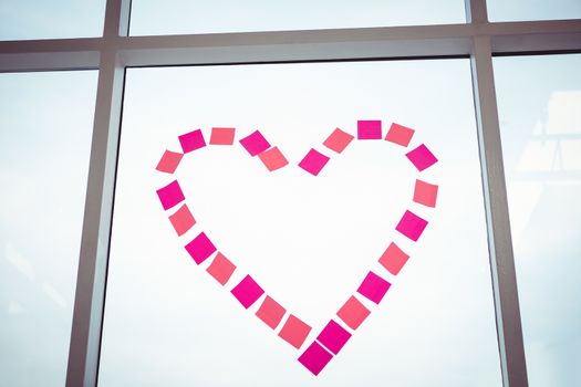 Heart in post-it on a window in office