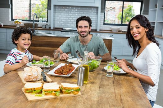 Happy family having lunch together in kitchen at home