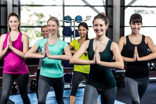 Fitness class doing yoga exercises in the gym