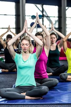 Fit smiling group doing yoga in gym