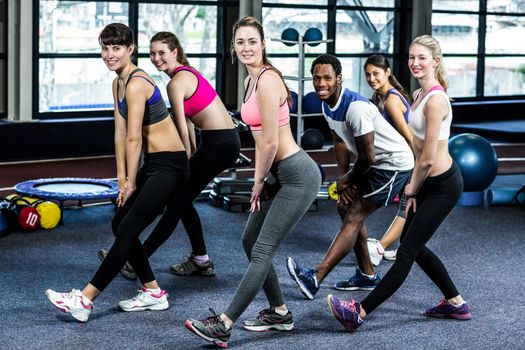 Fit smiling group doing exercise in gym