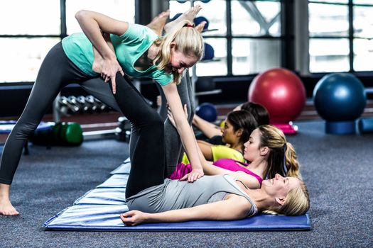 Fit smiling group doing stretching in gym