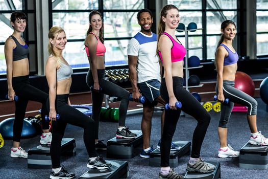 Fit smiling group doing exercise in gym