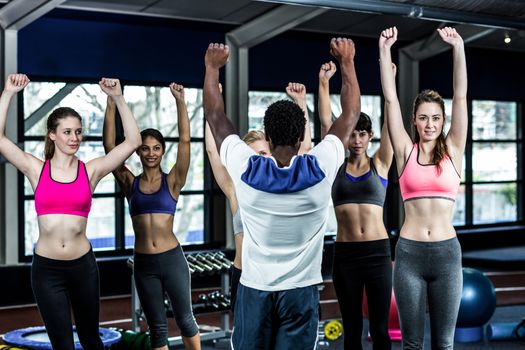 Fit smiling group doing exercise in gym