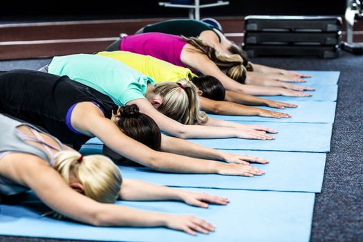 Fitness class doing yoga exercises in the gym