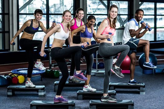 Fit smiling group doing exercise in gym