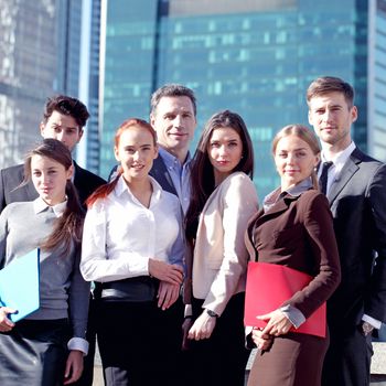 Portrait of business team outside office on skyscrapers background