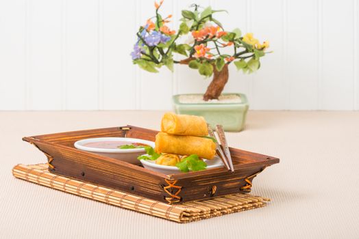 Spring roll appetizers served with a sweet and spicy sauce.