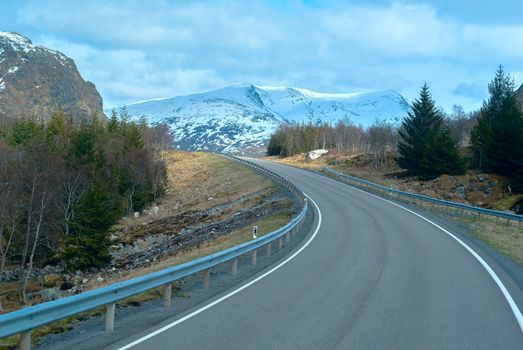 Grey asphalt road in Norvegian mountains in summer day