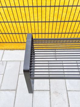 Bright yellow playground and metal bench. Urban architecture.