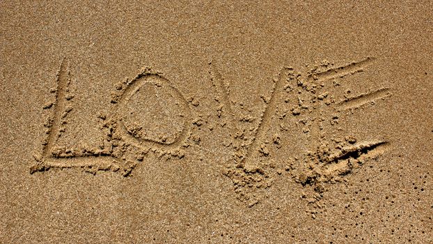 love message written in sand at beach