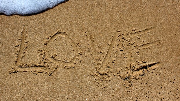 love message written in sand at beach