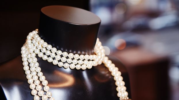 Pearl necklace on black mannequin at boutique