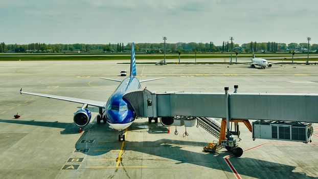 Airplane at the terminal gate ready for takeoff - Modern international airport during sunset - Concept of emotional travel around the world