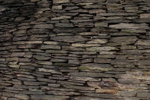 Stone wall made of dark gray stones 