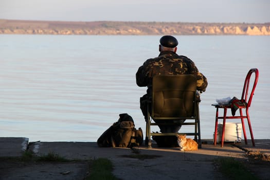 fisherman on the river wit red cat