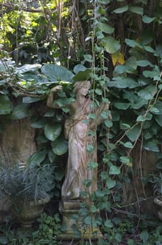 Sculpture covered with moss in garden