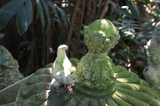 Sculpture covered with moss in garden