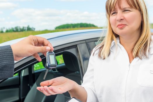 the seller presents the woman key from the new car