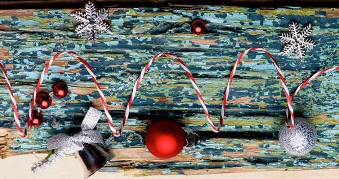 New Year Decoration with Red and Silver Baubles, Silver Stars and Striped Party Streamer closeup on Cracked Wooden Plank