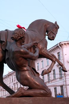 Klodt statue with horse and young man in St. Petersburg, Russia. Christmas hat on mans head