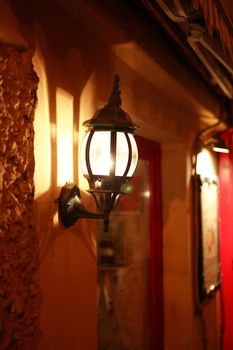 Nice luminous street lamp on building wall at night