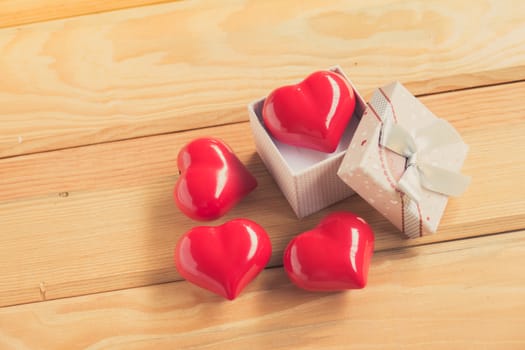 Gift of love. hearty gift. A gift box with a red heart inside. On the wooden floor