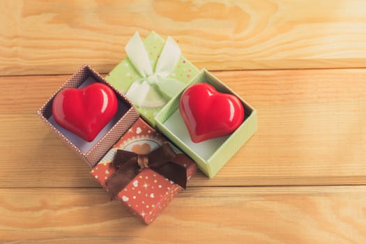 Gift of love. hearty gift. A gift box with a red heart inside. On the wooden floor