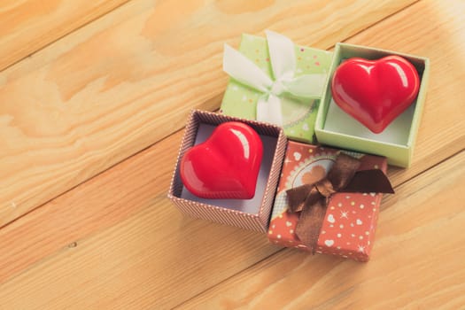 Gift of love. hearty gift. A gift box with a red heart inside. On the wooden floor