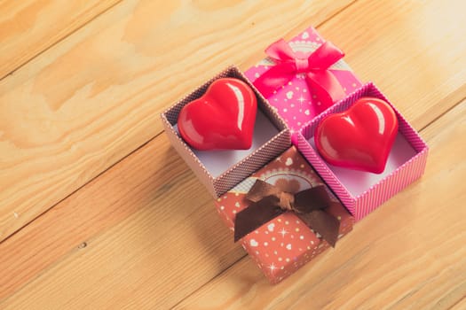 Gift of love. hearty gift. A gift box with a red heart inside. On the wooden floor