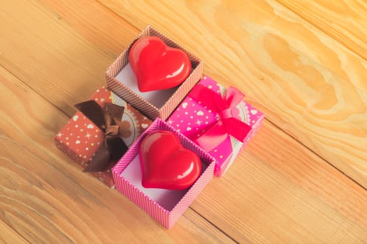 Gift of love. hearty gift. A gift box with a red heart inside. On the wooden floor