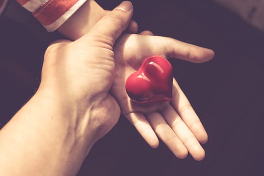 Red Heart in a gift box, in the hands of a girl. valentine background