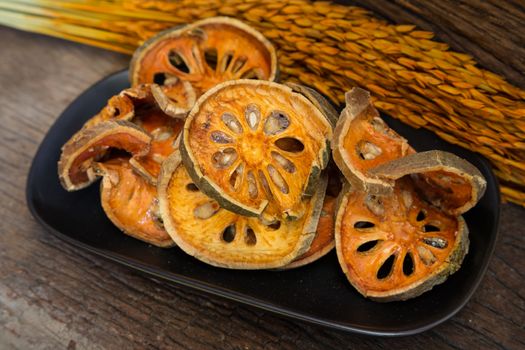 Dry Bael Fruit tea (Aegle marmelos) on dark vintage wood.