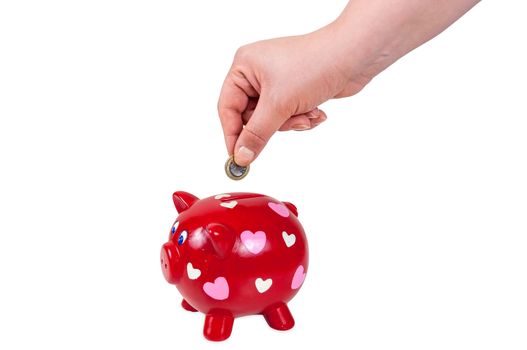 Hand inserting coin into piggy bank isolated on white background with clipping path