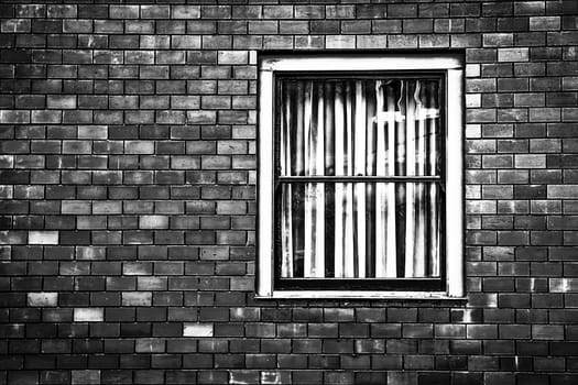 window with old brick wall building in black and white