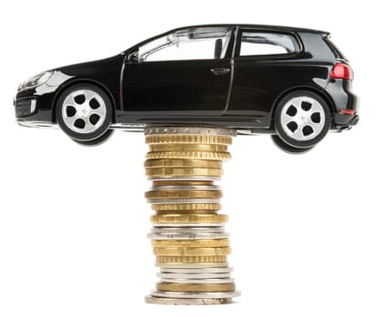 Car on stack of coins isolated on white background