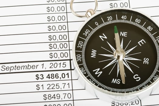 Compass with cash and calculator on bills background