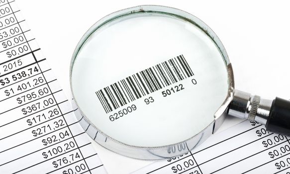 Magnifier with barcode on bills background, close up view