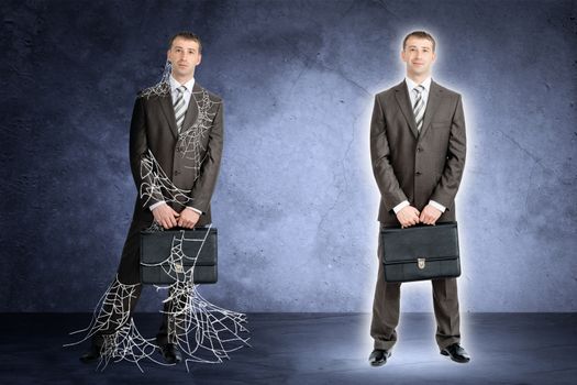 Two businessman in spider web looking at camera on grey background 